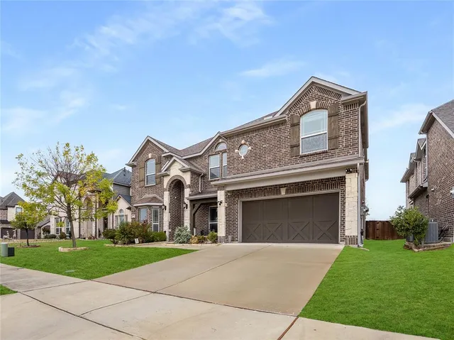 a front view of a house with a garden and yard