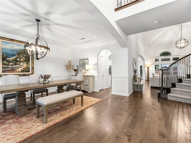 a living room with couches a dining table and chairs with wooden floor