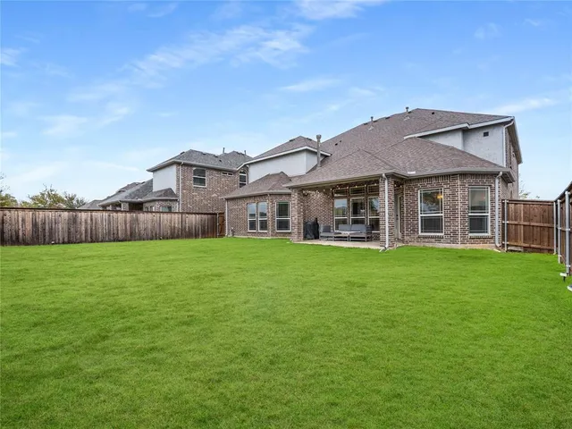 a view of yard with grass and wooden fence