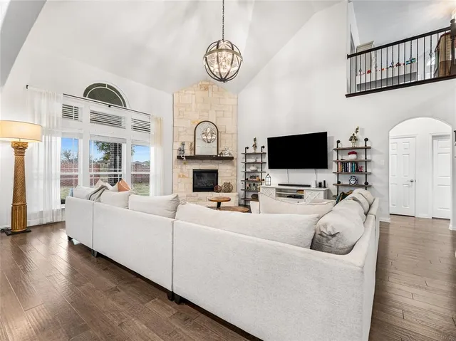 a living room with furniture a flat screen tv and a fireplace