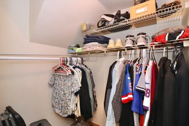 a view of walk in closet with clothes and shoes