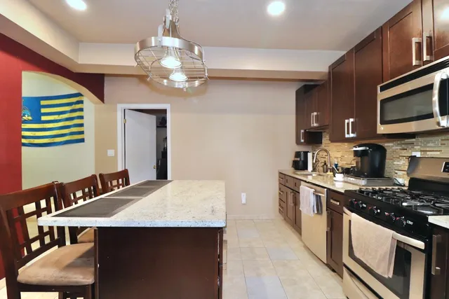 a kitchen with stainless steel appliances a sink stove and refrigerator