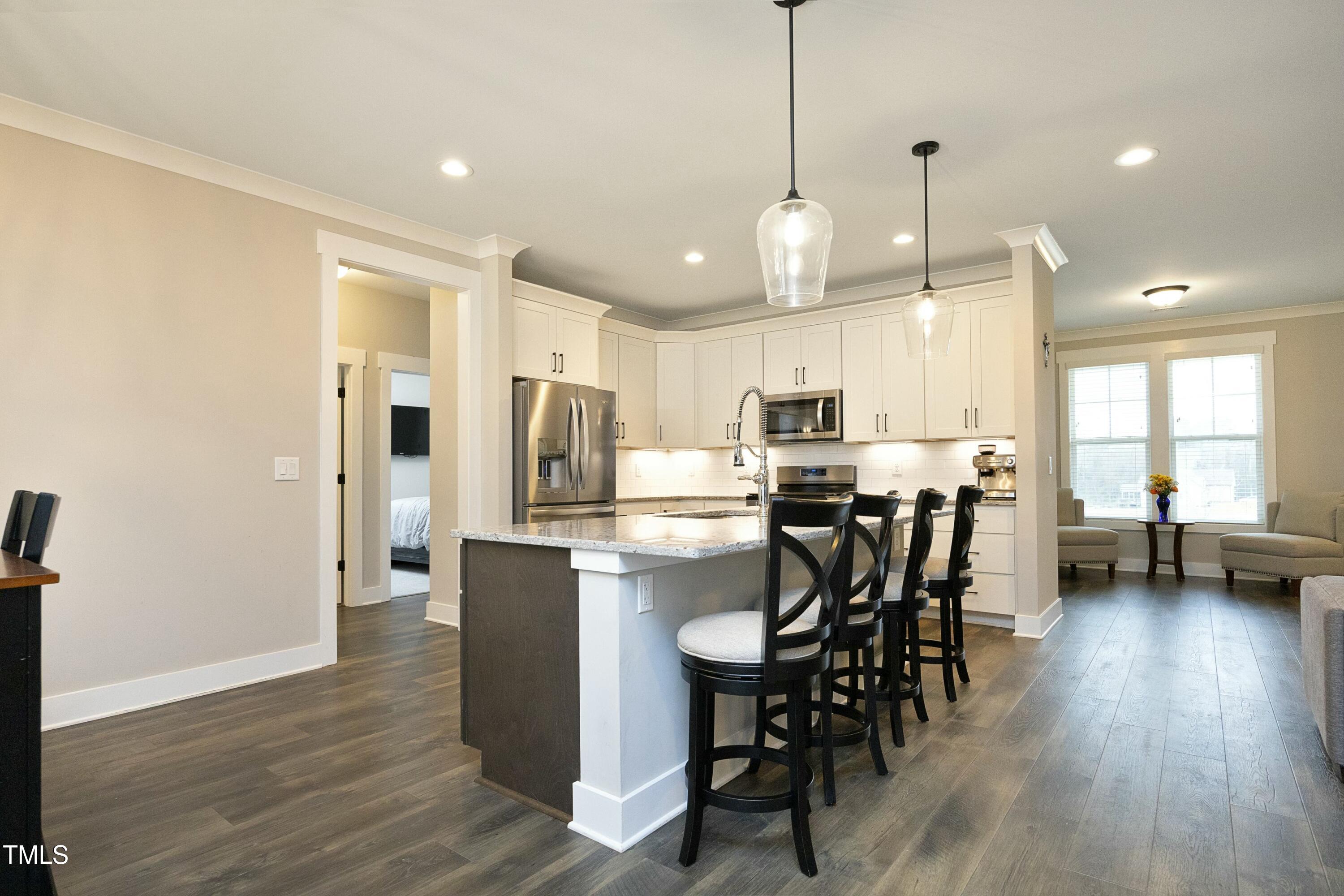 97 Buckstone Place Willow Spring, NC 27592 - Photo 11 of 33 a kitchen with stainless steel appliances a dining table chairs stove refrigerator and cabinets