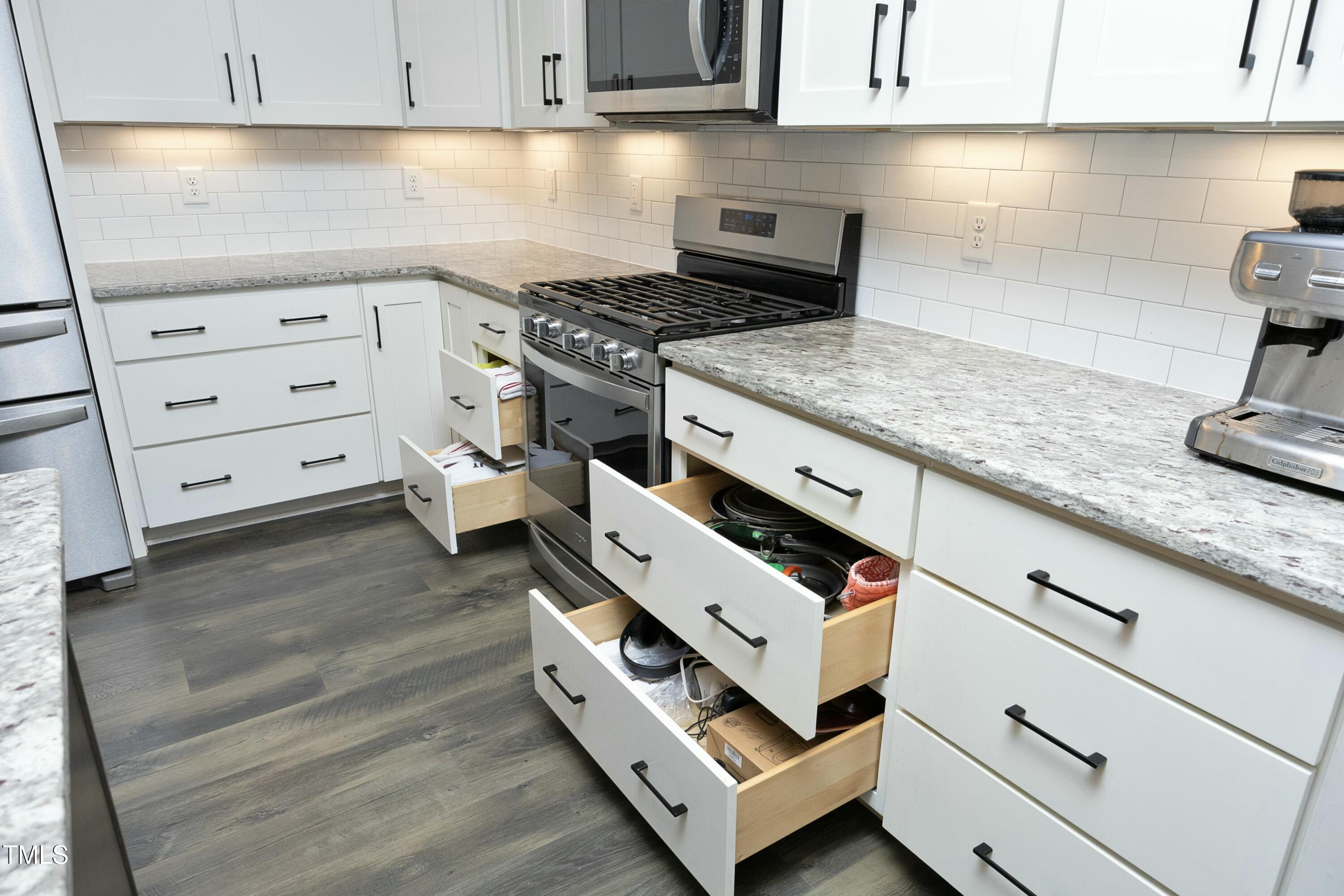 97 Buckstone Place Willow Spring, NC 27592 - Photo 14 of 33 a kitchen with granite countertop a stove oven and white cabinets