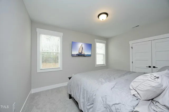 a bedroom with a bed and a chair with the view