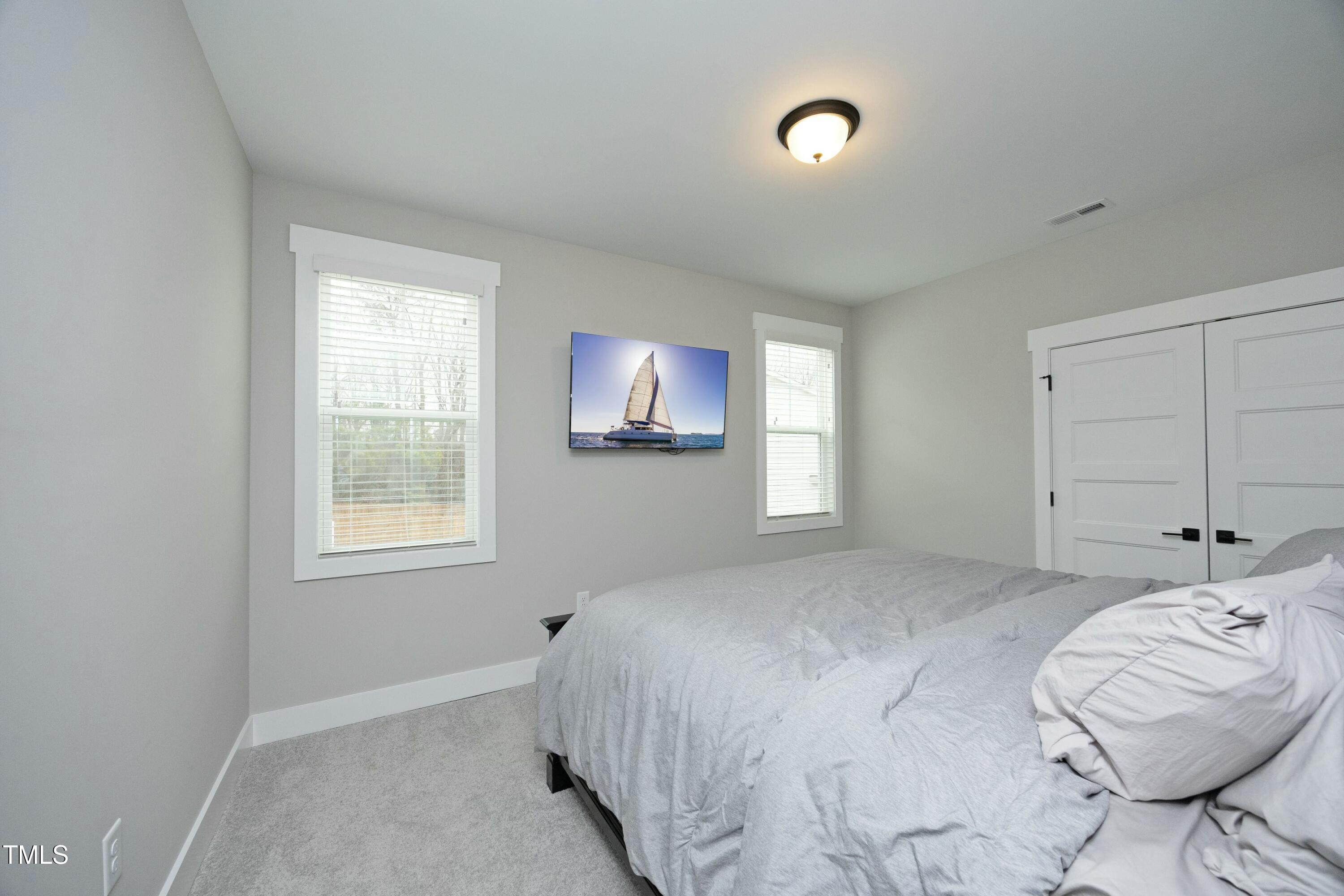 97 Buckstone Place Willow Spring, NC 27592 - Photo 22 of 33 a bedroom with a bed and a chair with the view