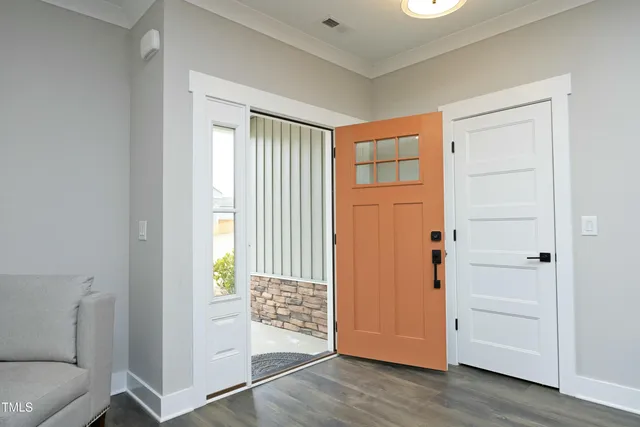 an empty room with wooden floor cabinet and front door