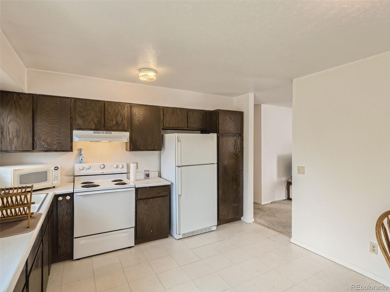 1632 South Rifle Street Aurora, CO 80017 - Photo 11 of 26 a kitchen with a stove a refrigerator and a sink