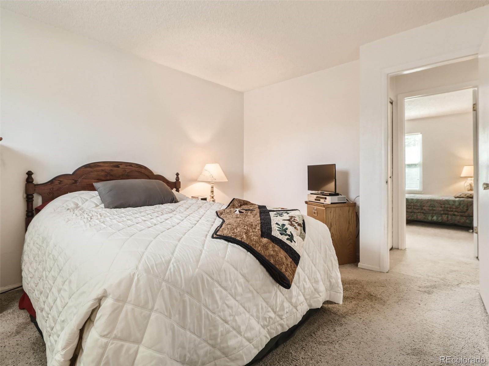 1632 South Rifle Street Aurora, CO 80017 - Photo 18 of 26 a bedroom with a bed and a view of living room