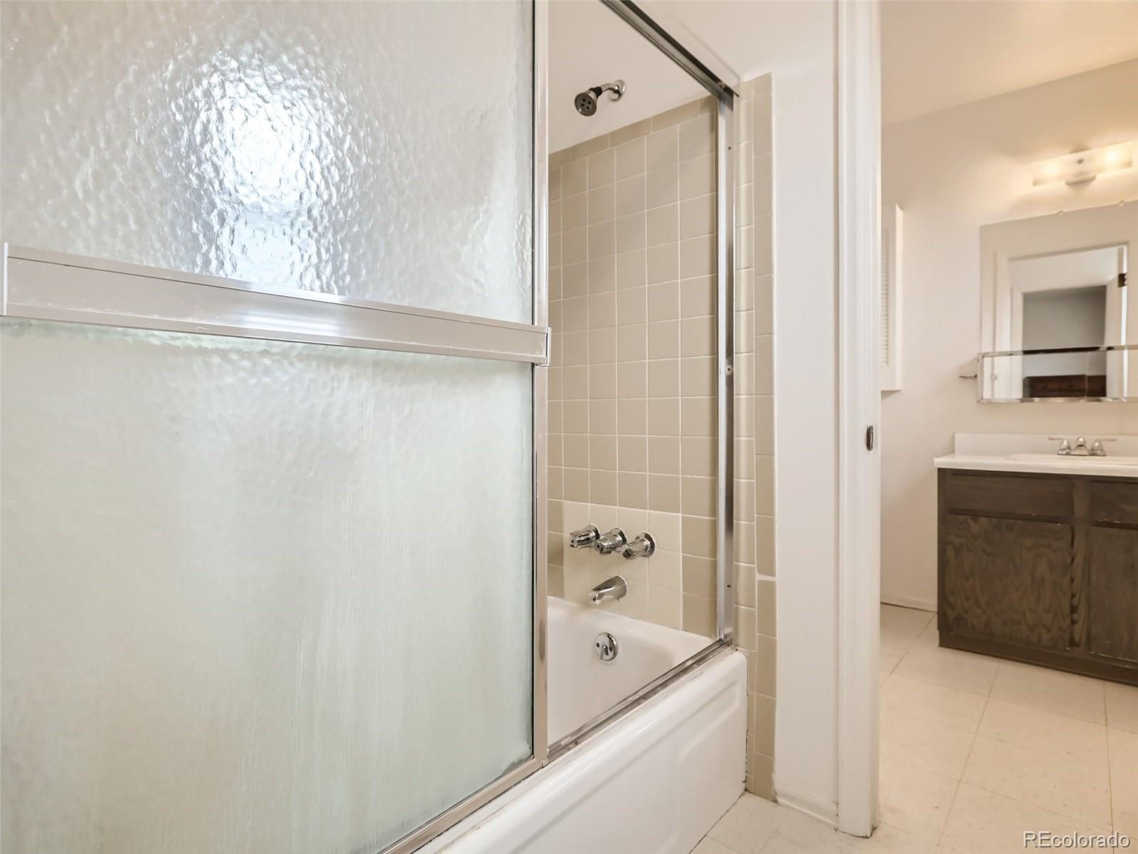 1632 South Rifle Street Aurora, CO 80017 - Photo 20 of 26 a bathroom with a tub a sink and mirrors