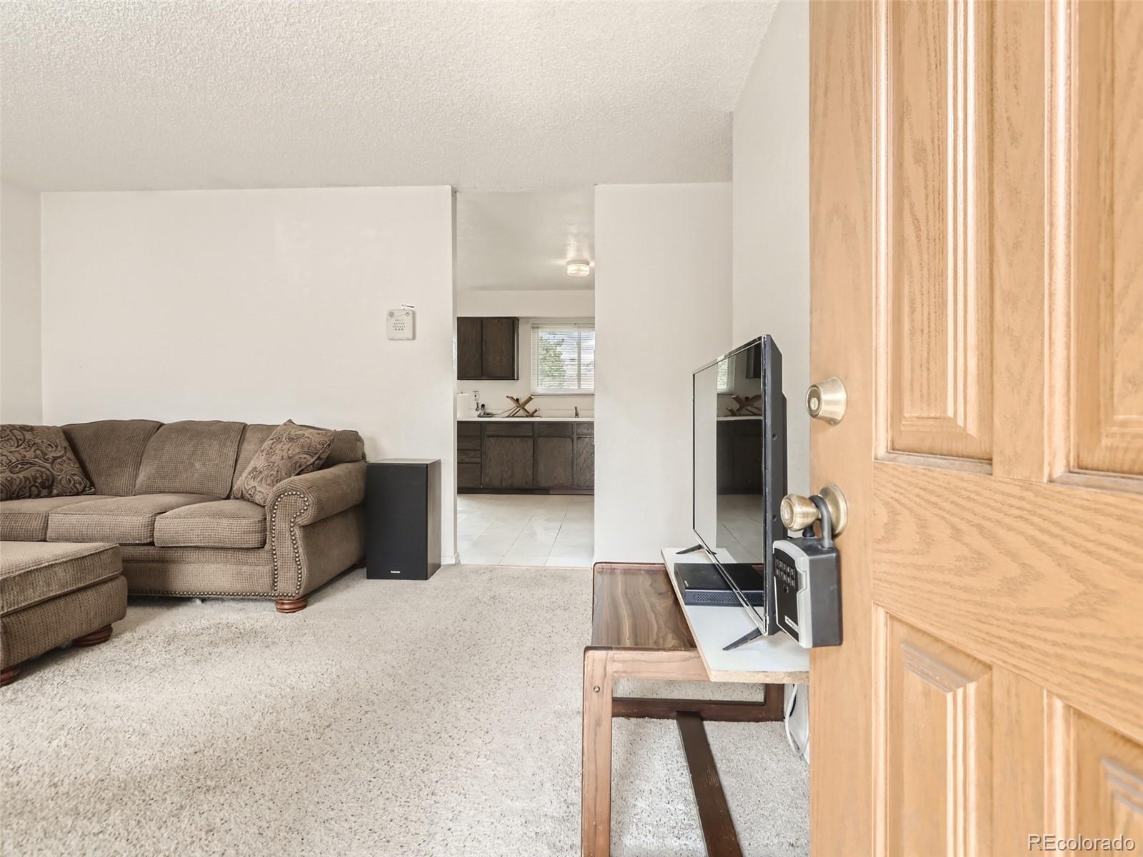 1632 South Rifle Street Aurora, CO 80017 - Photo 5 of 26 a living room with furniture and a flat screen tv