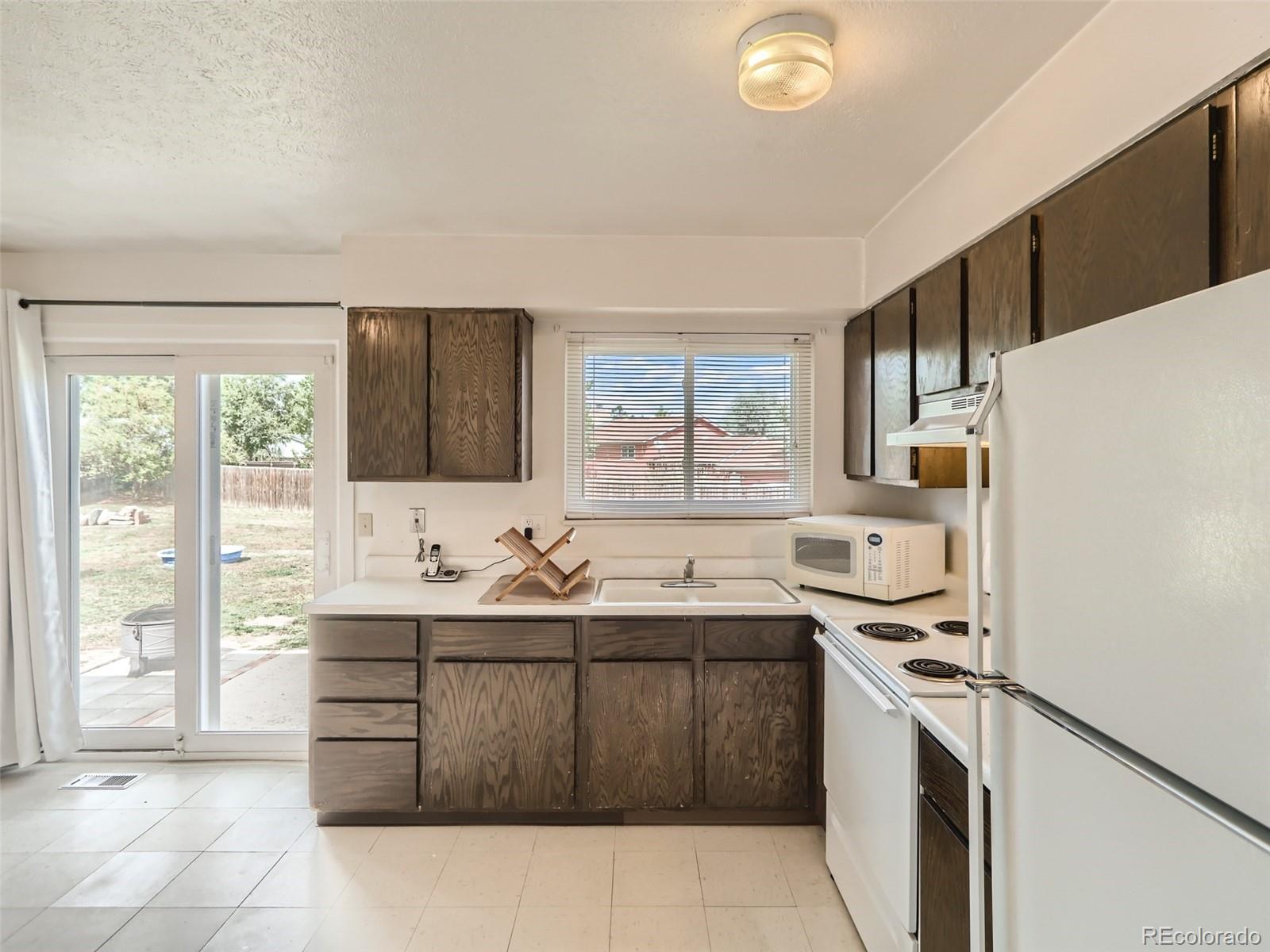 1632 South Rifle Street Aurora, CO 80017 - Photo 10 of 26 a kitchen with a sink a stove a refrigerator and a window