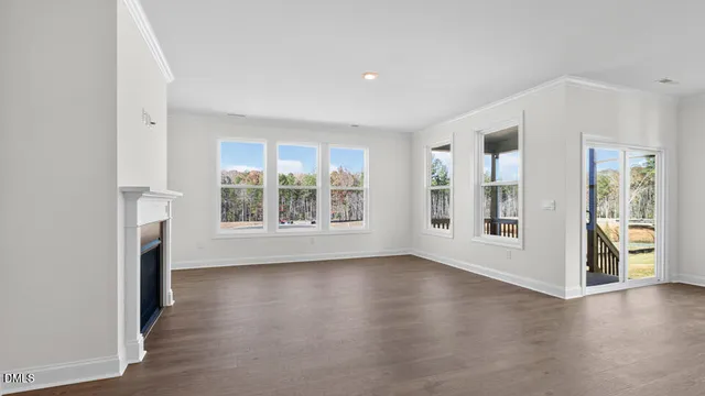 an empty room with windows and fireplace
