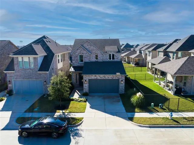 an aerial view of a house with a yard and large tree
