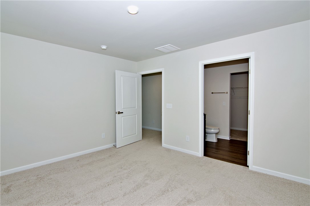 723 Peridot Way Westminster, SC 29693 - Photo 19 of 45 A well-lit bedroom features plush carpeting and convenient access to a private bathroom with a walk-in closet.