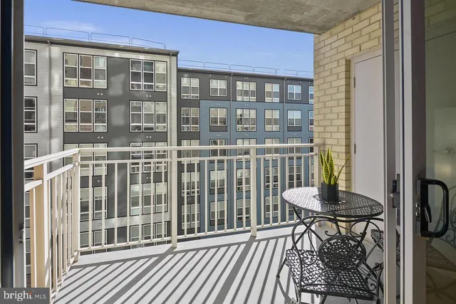 a view of a brick house with a chairs and table in a patio