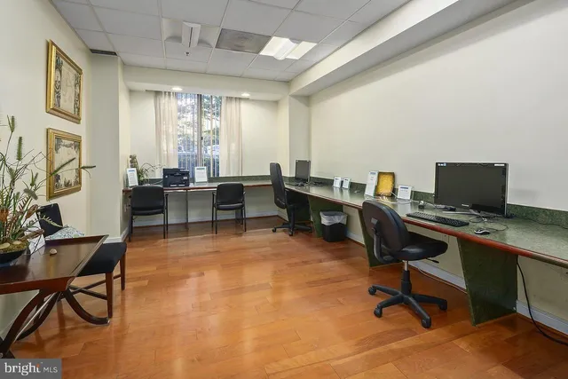 a view of a workspace with furniture and a window