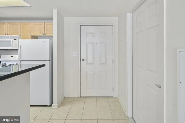 a view of kitchen with refrigerator and window