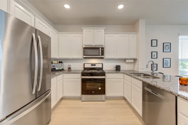 a kitchen with stainless steel appliances a stove sink microwave and cabinets