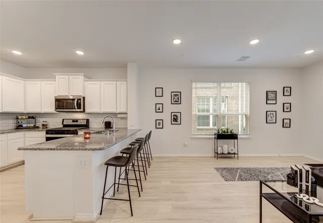 a kitchen with stainless steel appliances granite countertop a refrigerator stove and sink