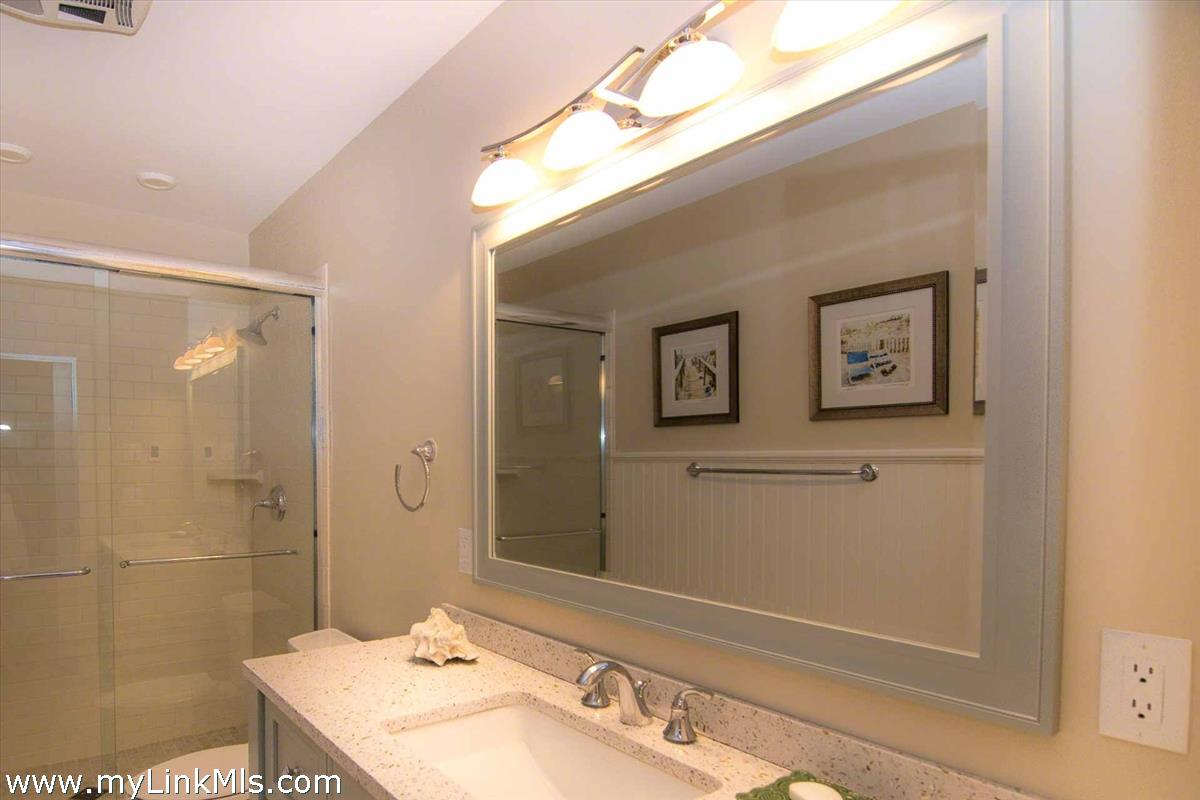 10 Codman Spring Road Edgartown, MA 02539 - Photo 14 of 30 a bathroom with a sink a mirror and a shower