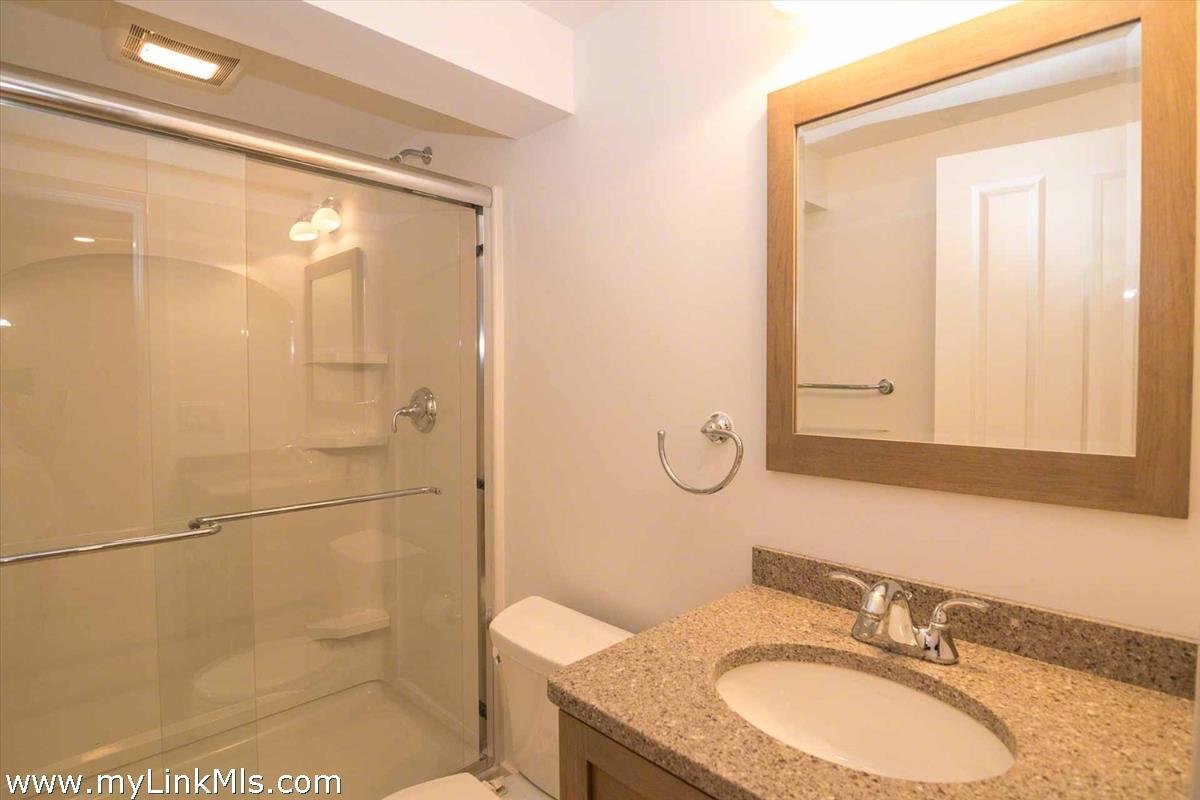 10 Codman Spring Road Edgartown, MA 02539 - Photo 25 of 30 a bathroom with a granite countertop sink a mirror and a shower