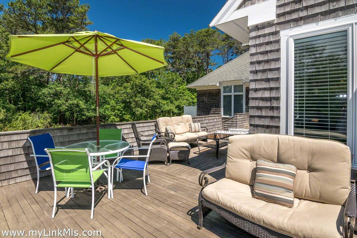 10 Codman Spring Road Edgartown, MA 02539 - Photo 28 of 30 a view of a patio with a table and chairs under an umbrella