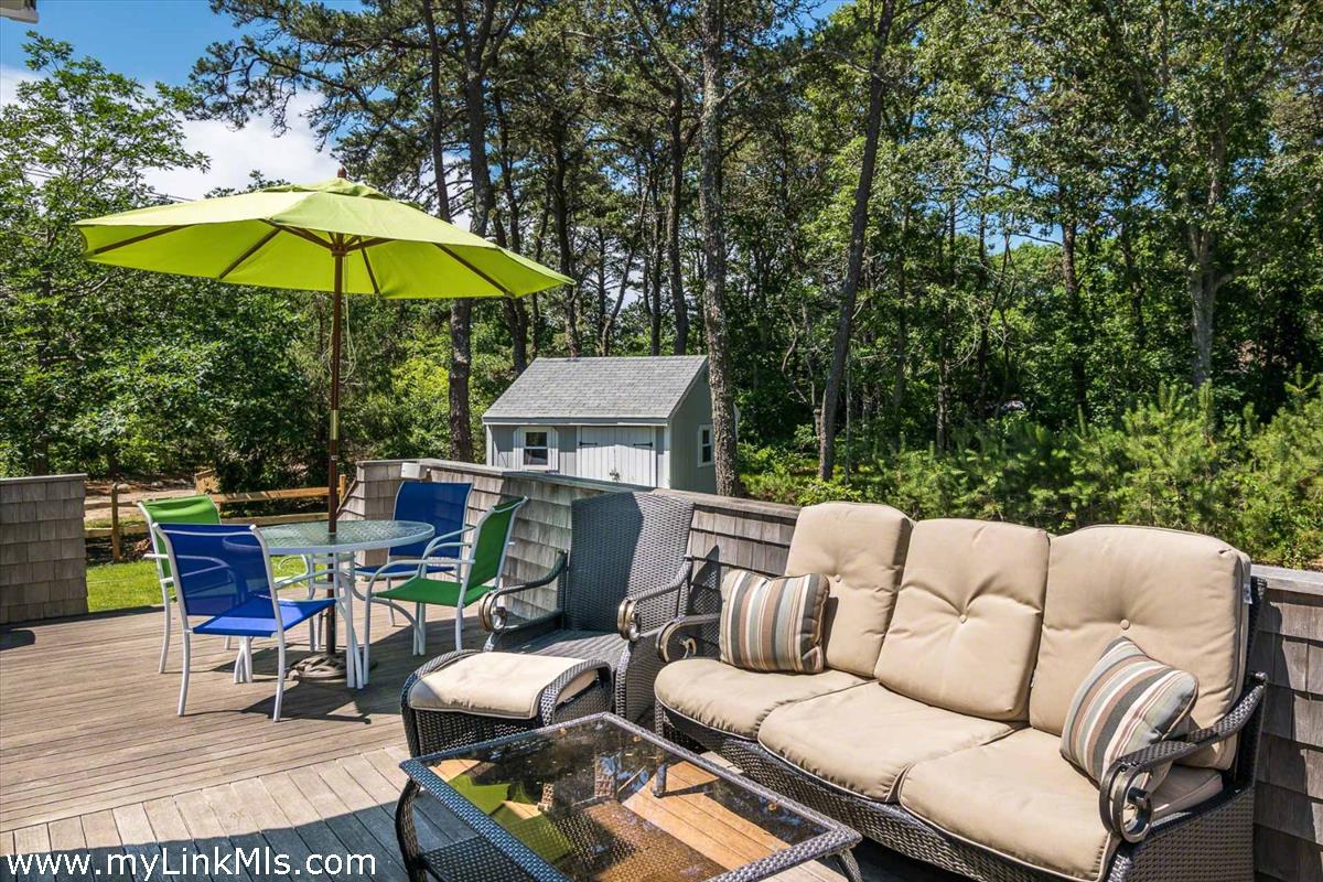 10 Codman Spring Road Edgartown, MA 02539 - Photo 29 of 30 a roof deck with a table and chairs under an umbrella