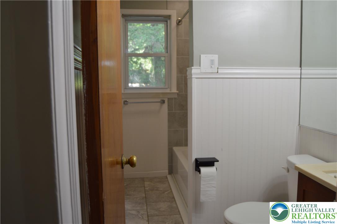 1819 Blue Barn Road Orefield, PA 18069 - Photo 16 of 21 A window-lit bathroom featuring a tiled floor and a bathtub with tiled surround.