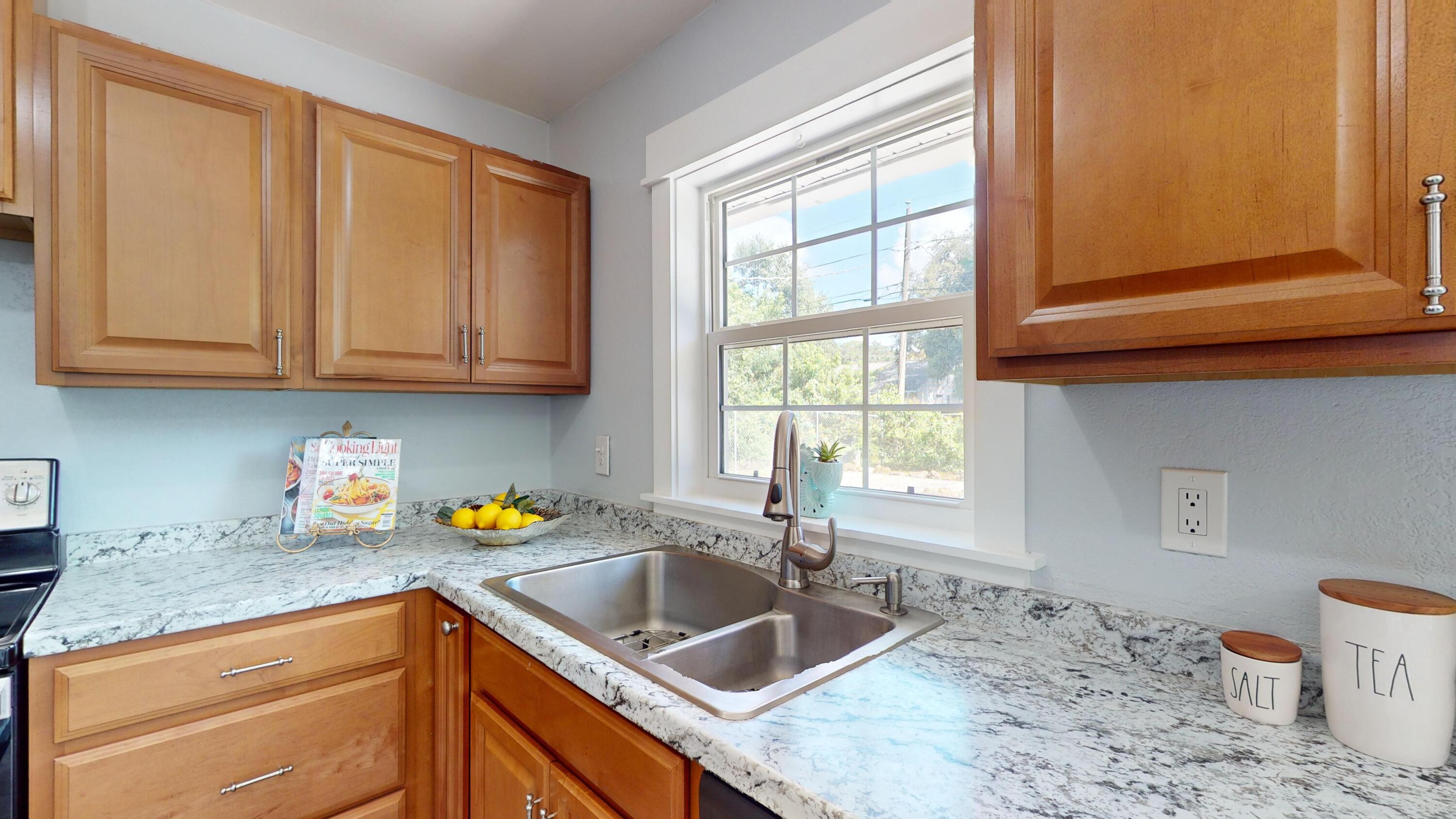 7606 Donlon Road Fort Pierce, FL 34951 - Photo 13 of 54 a kitchen with granite countertop a sink a stove and cabinets