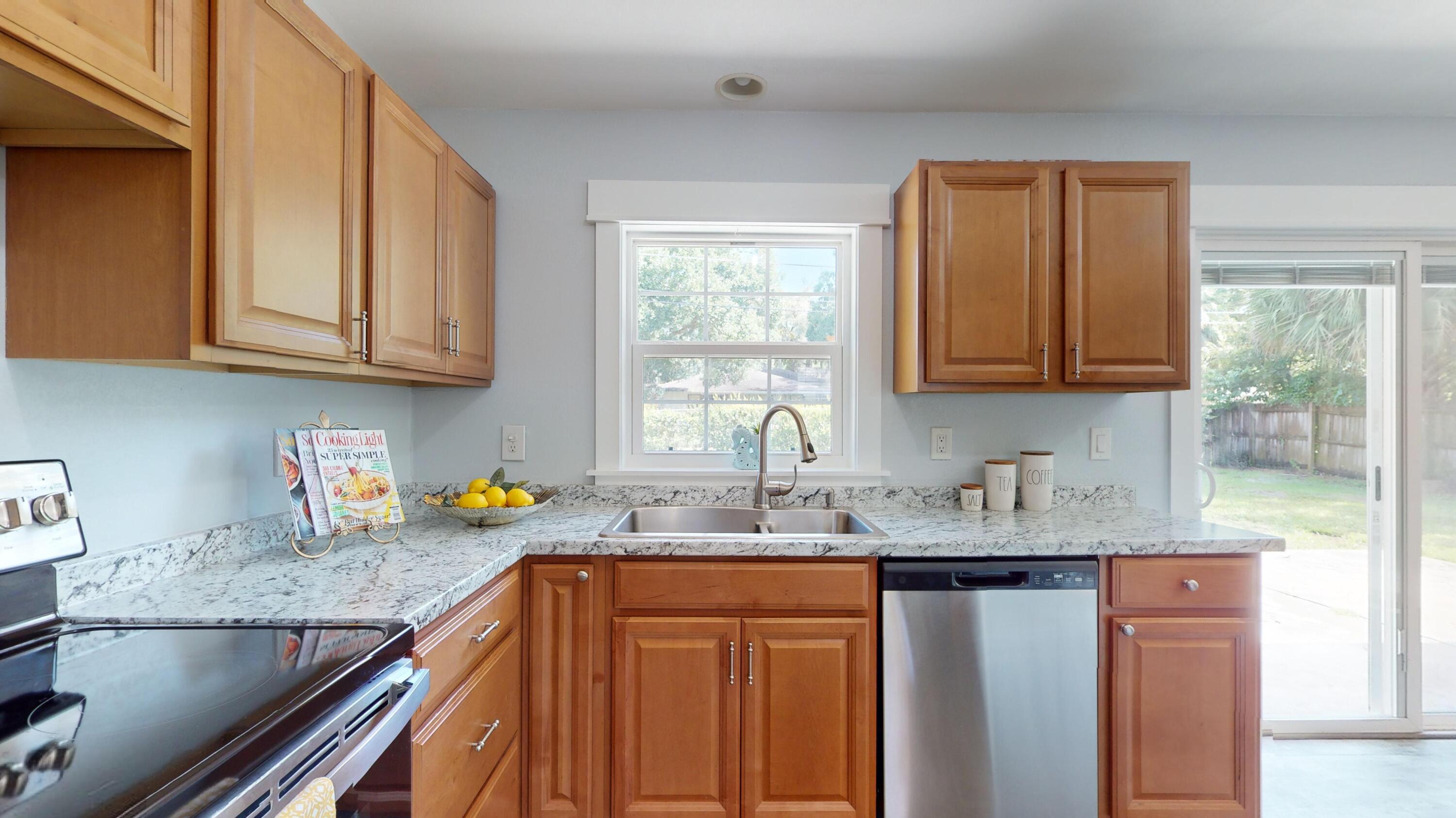 7606 Donlon Road Fort Pierce, FL 34951 - Photo 14 of 54 a kitchen with stainless steel appliances granite countertop a sink stove and cabinets