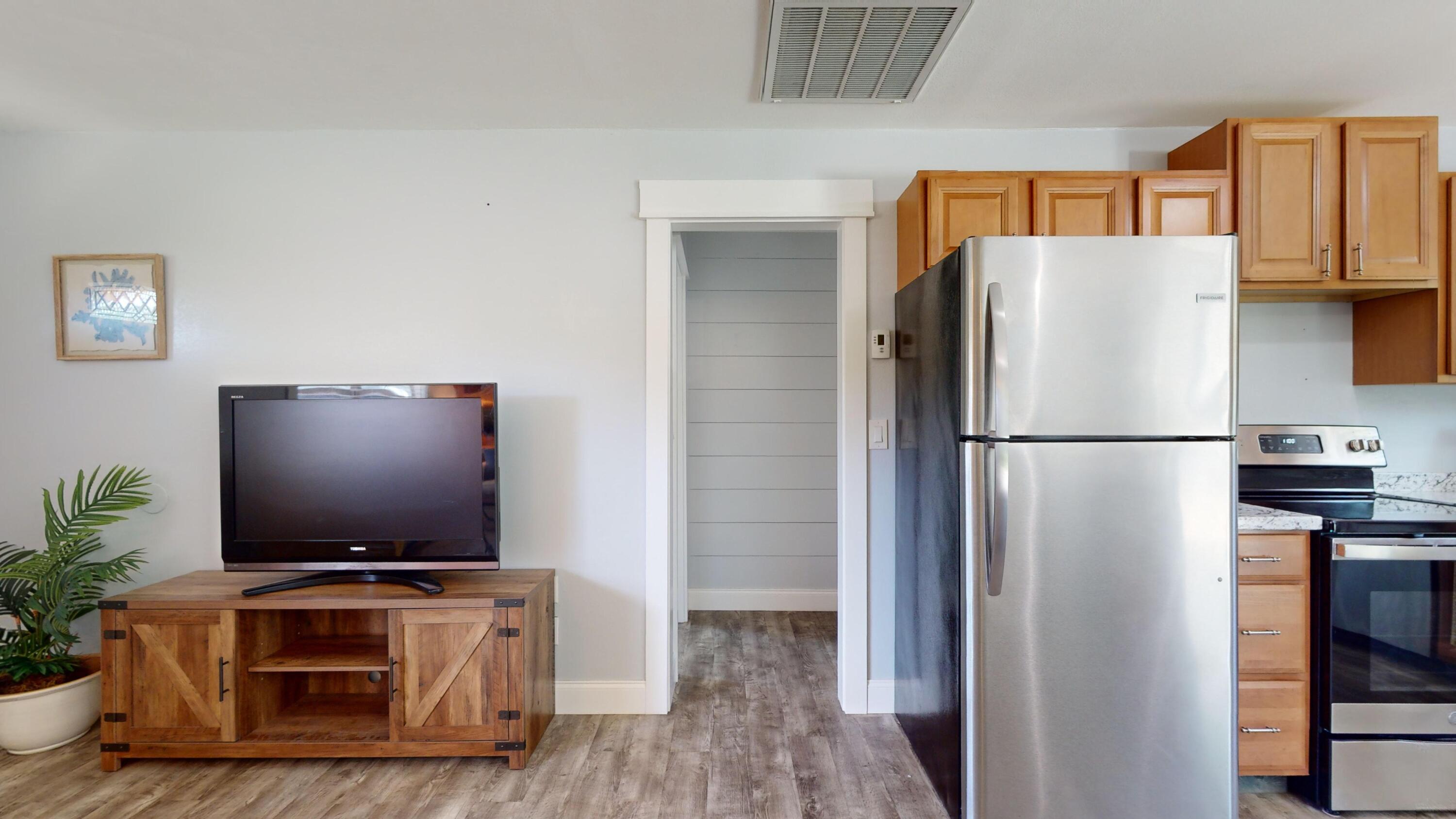 7606 Donlon Road Fort Pierce, FL 34951 - Photo 18 of 54 a living room with stainless steel appliances furniture a refrigerator and a flat screen tv