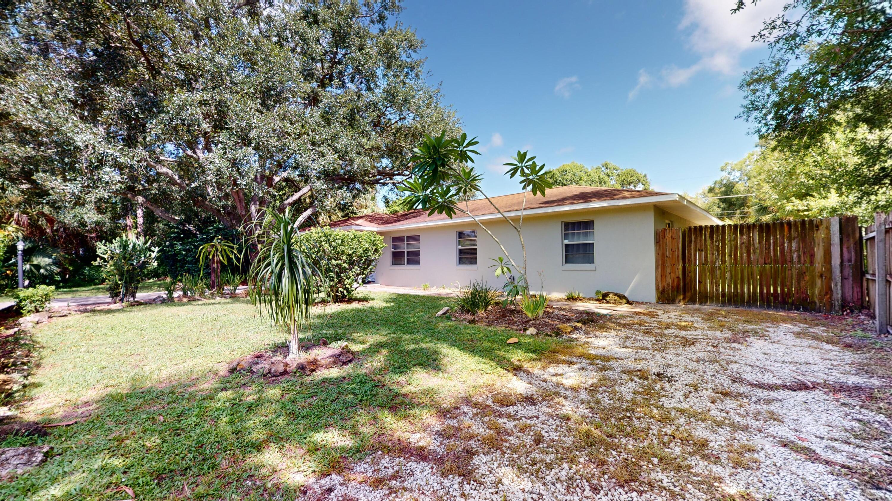 7606 Donlon Road Fort Pierce, FL 34951 - Photo 45 of 54 a backyard of a house with table and chairs and wooden fence