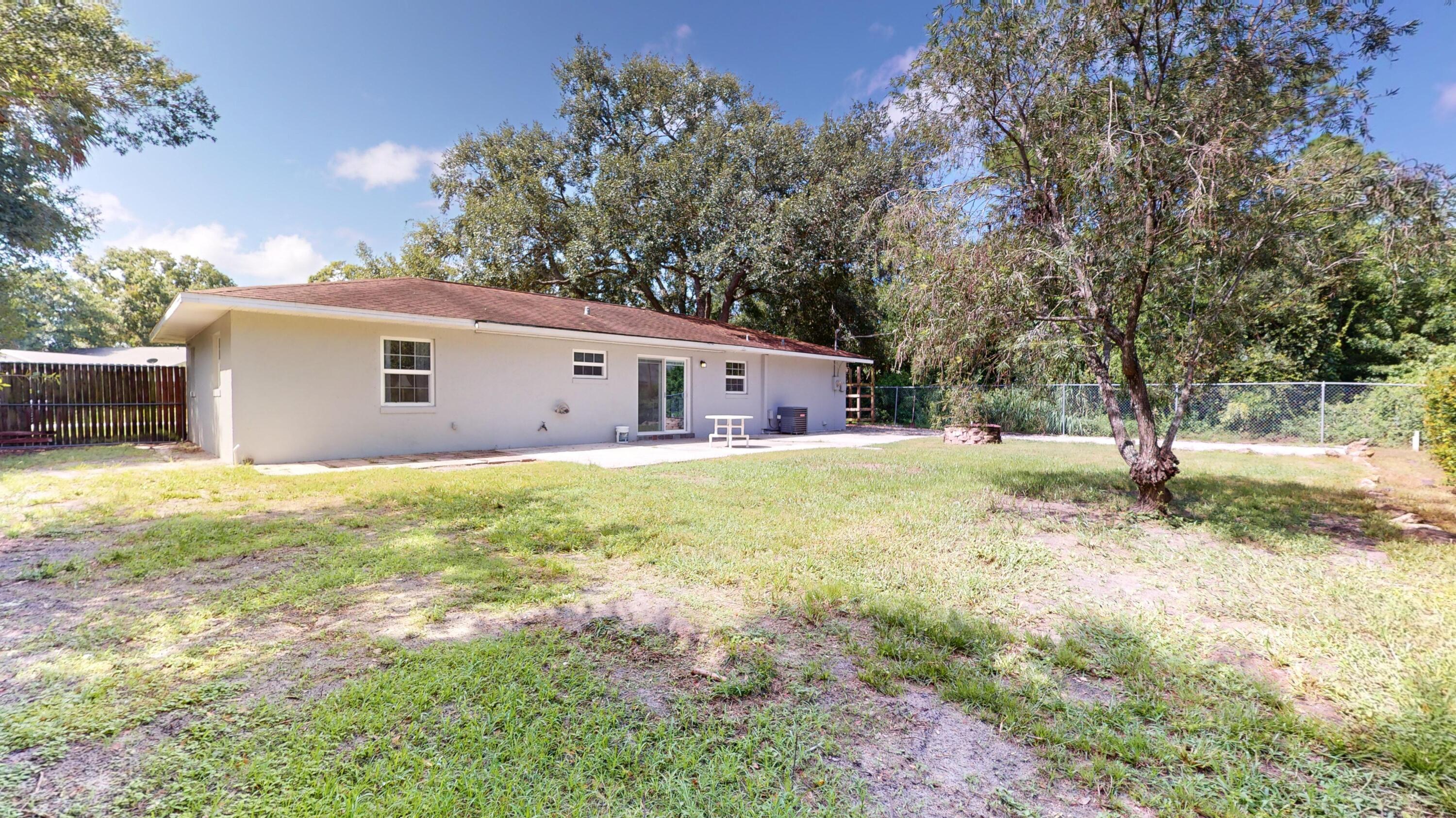 7606 Donlon Road Fort Pierce, FL 34951 - Photo 47 of 54 a front view of house with yard and trees