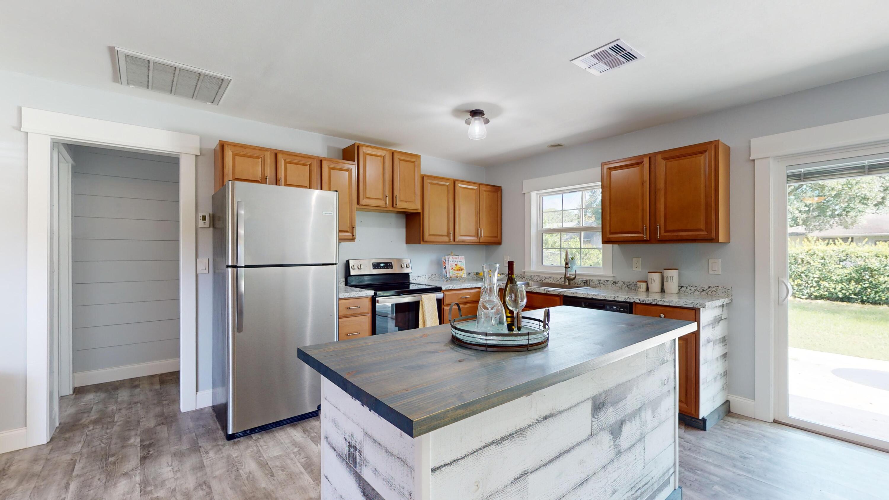 7606 Donlon Road Fort Pierce, FL 34951 - Photo 10 of 54 a kitchen with a refrigerator a stove a microwave and wooden floor