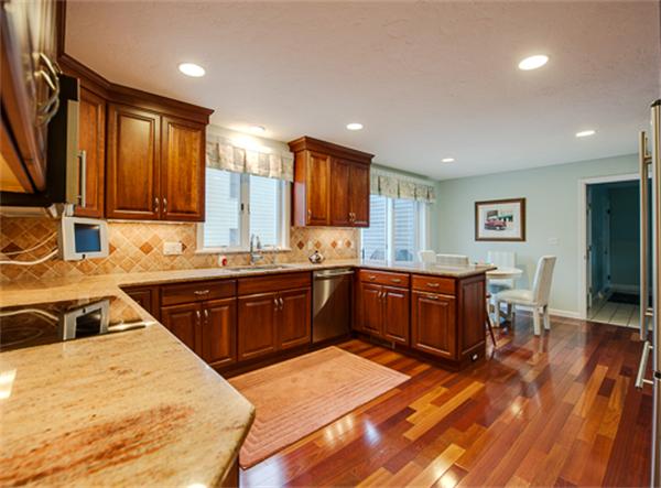 20 William Street Needham, MA 02494 - Photo 2 of 16 a kitchen with stainless steel appliances granite countertop a sink a stove a refrigerator cabinets and wooden floor