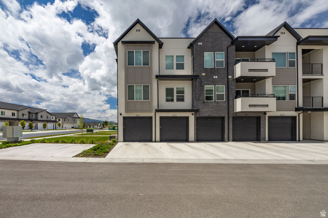 3115 South 200 West, Unit C201 Nibley, UT 84321 - Photo 17 of 23 Contemporary townhome-style residences featuring multi-level facades with varied siding, private balconies, and integrated garages