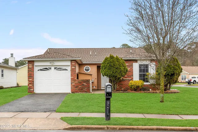 a front view of a house with a garden and yard