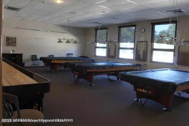 a room with furniture pool table and a large window