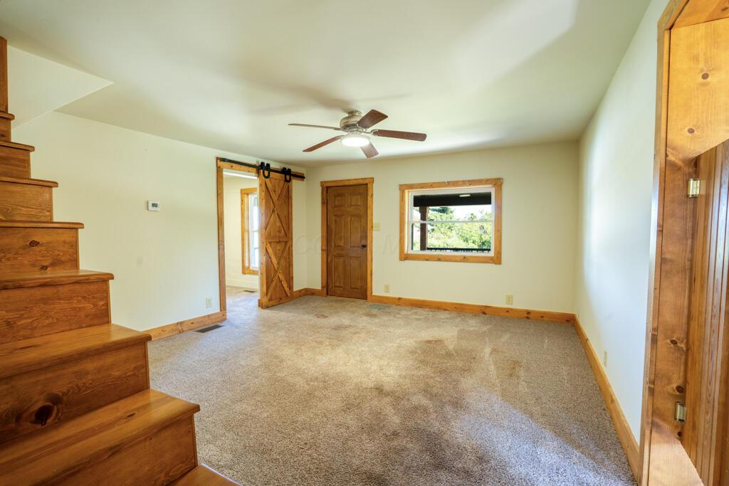 681 Downing Road Stockport, OH 43787 - Photo 27 of 36 Living Room with Staircase Ceiling Fan a
