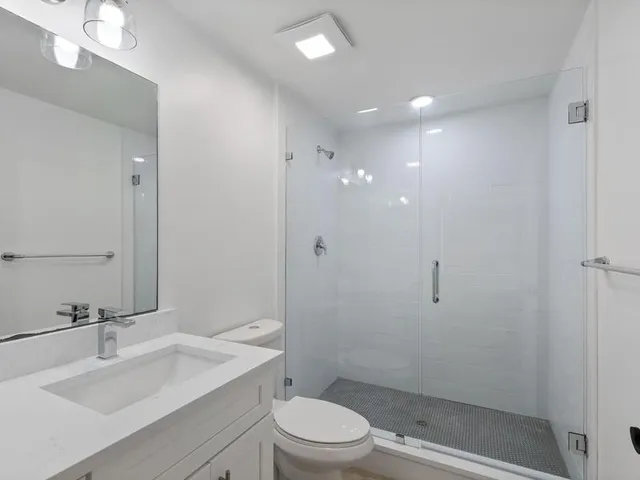 a bathroom with a sink a toilet and shower