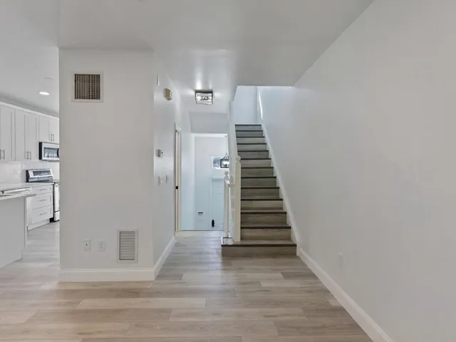 a view of a hallway with wooden floor and entryway