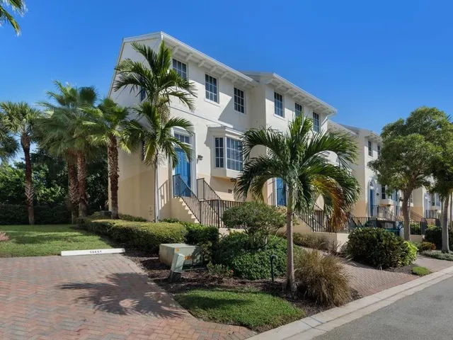 a front view of multiple houses with yard