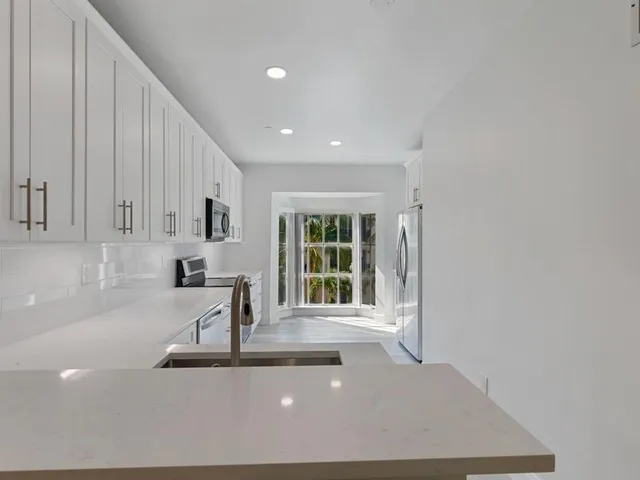 a view of a kitchen with a sink and large window