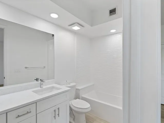 a bathroom with a sink a toilet and a large mirror