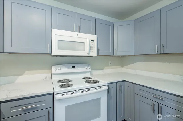 a view of a kitchen with white cabinets