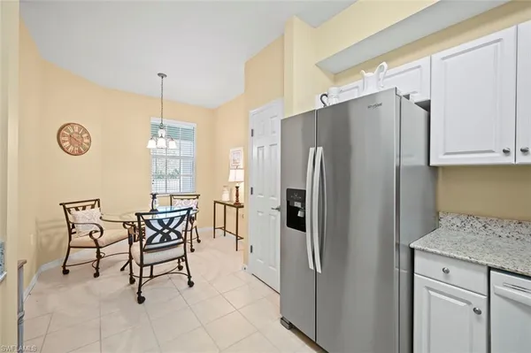 a kitchen with stainless steel appliances a refrigerator a table and chairs