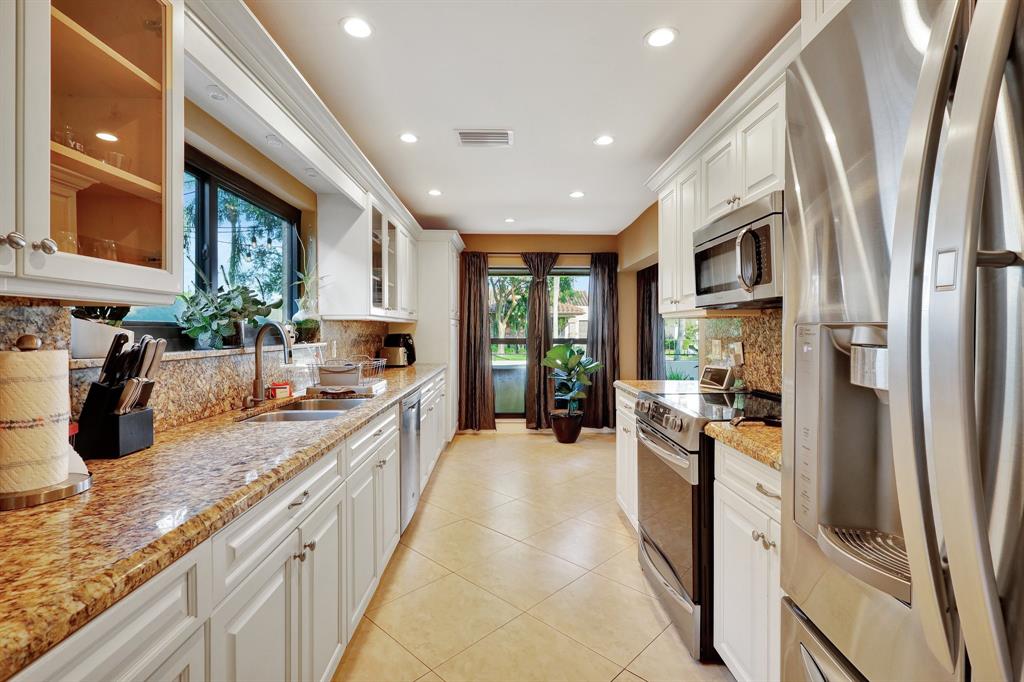 6810 Allegre Court Boca Raton, FL 33433 - Photo 12 of 29 a kitchen with sink refrigerator and stove