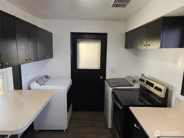 a kitchen with a refrigerator and a stove top oven