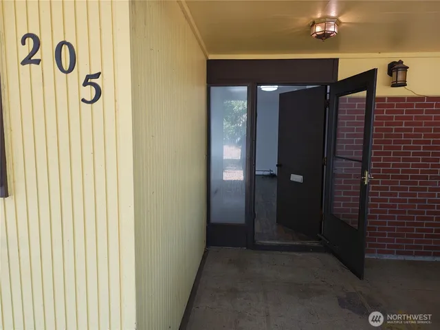 a view of a hallway with a door and wooden floor